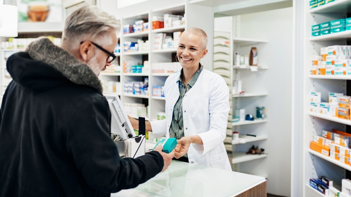 Man collects medicine from pharmacist